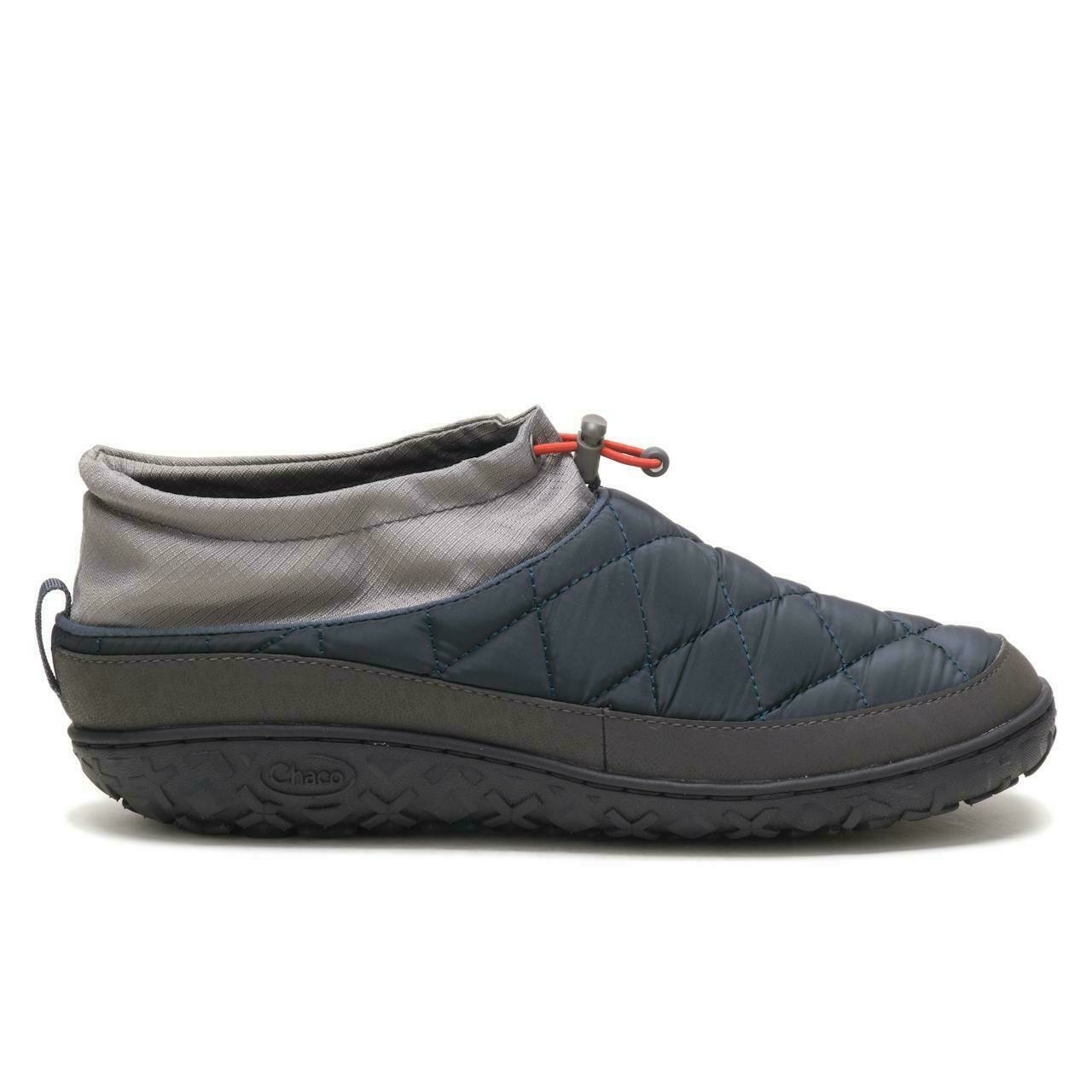 A quilted slipper with a drawstring closure rests against a plain background. It features a gray collar and a dark, textured rubber sole. The word "Chaco" is embossed on the sole.