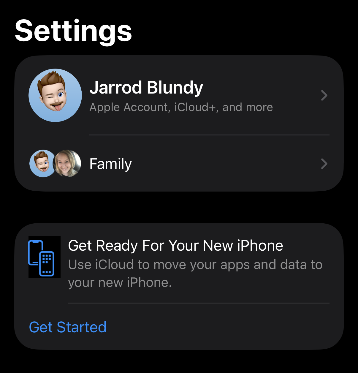 Screenshot of an iPhone settings screen. At the top is a section with a Memoji of a person winking and sticking out their tongue, labeled “Jarrod Blundy” with options for Apple Account and iCloud+. Below, there is a “Family” option with two circular images: one the same Memoji, the other a photo of a smiling person. At the bottom, there’s a section titled “Get Ready For Your New iPhone,” describing how to use iCloud to transfer apps and data, with a “Get Started” link. The background is black with white text.