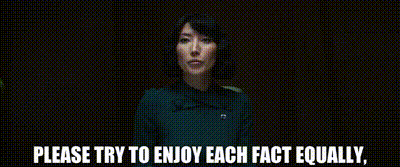 Ms. Casey from the TV show Severance, with short dark hair is speaking in a dimly lit room. She is wearing a dark teal outfit. The text at the bottom of the image reads, “PLEASE TRY TO ENJOY EACH FACT EQUALLY.”