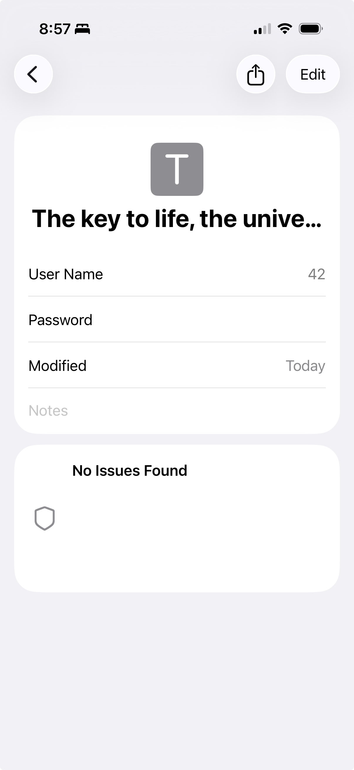 A mobile phone screenshot displays a password manager entry. At the top is a large “T” icon followed by the text, “The key to life, the unive…”. Below, it lists “User Name” with the number “42” next to it and “Password”, but no password is shown. “Modified” shows the date as “Today”. There’s a “No Issues Found” message with a shield icon. The screen includes options for sharing and editing. The time is shown as 8:57.